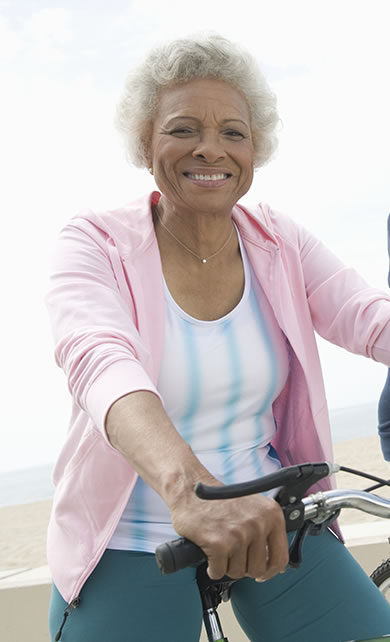 Mulher de meia idade andando de bicicleta sorrindo
