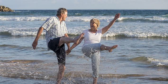 Casal de idosos brincando na praia