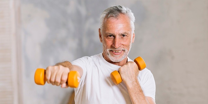 Idoso fazendo exercicios com peso no braco Idoso fazendo exercicios com peso no braco